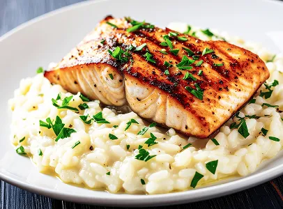 Filet de saumon grillé sur un lit de risotto crémeux garni de persil à Chénérailles dans la Creuse 23