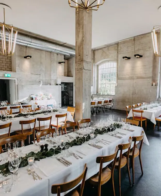 Salle de réception rustique et moderne avec de longues tables dressées pour un repas à Chénérailles dans la Creuse 23